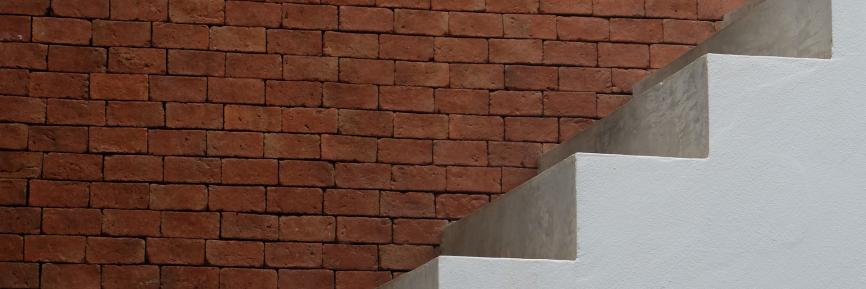 een bakstenen muur met betonnen trap